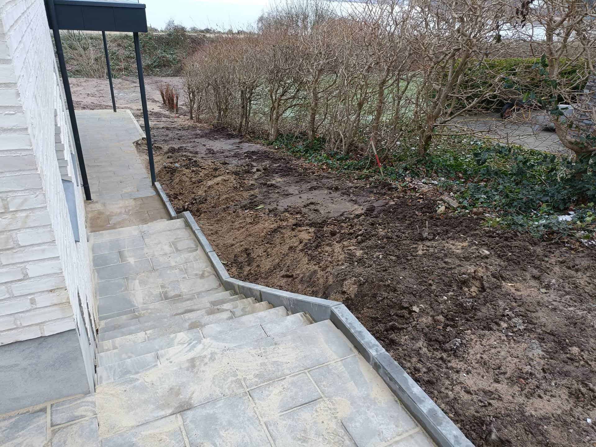 Fliser som lige er blevet lagt ved siden af et hus.